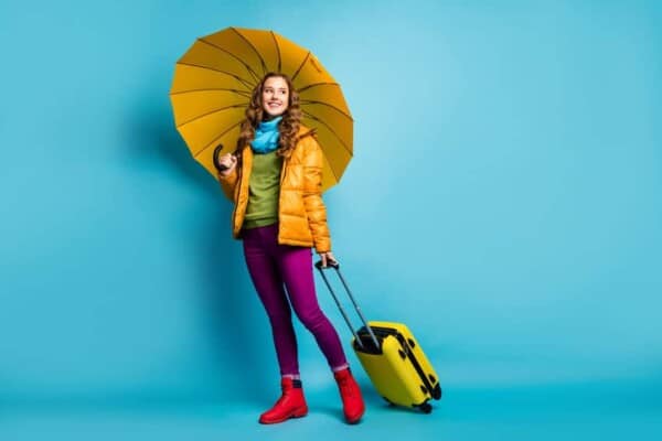 Lady carrying umbrella and travel case