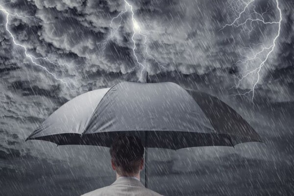 man holding umbrella in a storm