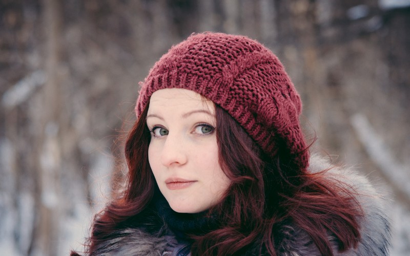 Woman with green eyes wearing a red hat