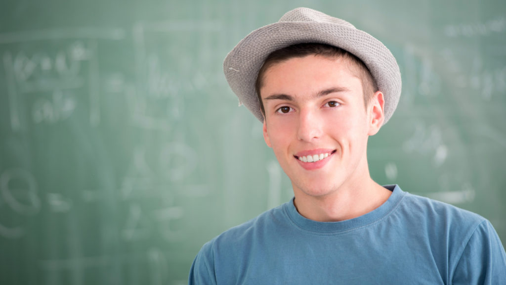 wearing hat in front of a black board