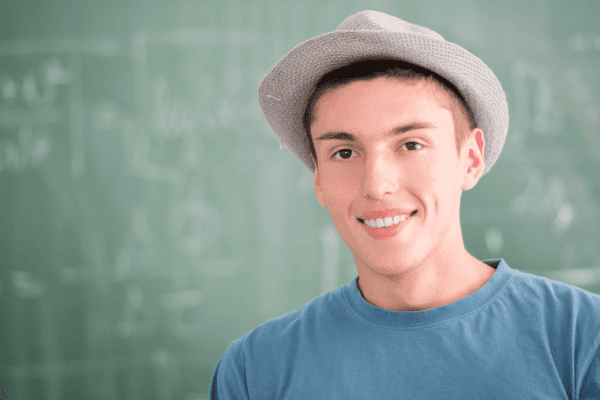 wearing hat in front of a black board