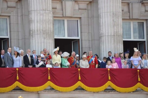 British royals wearing hats on a balcony
