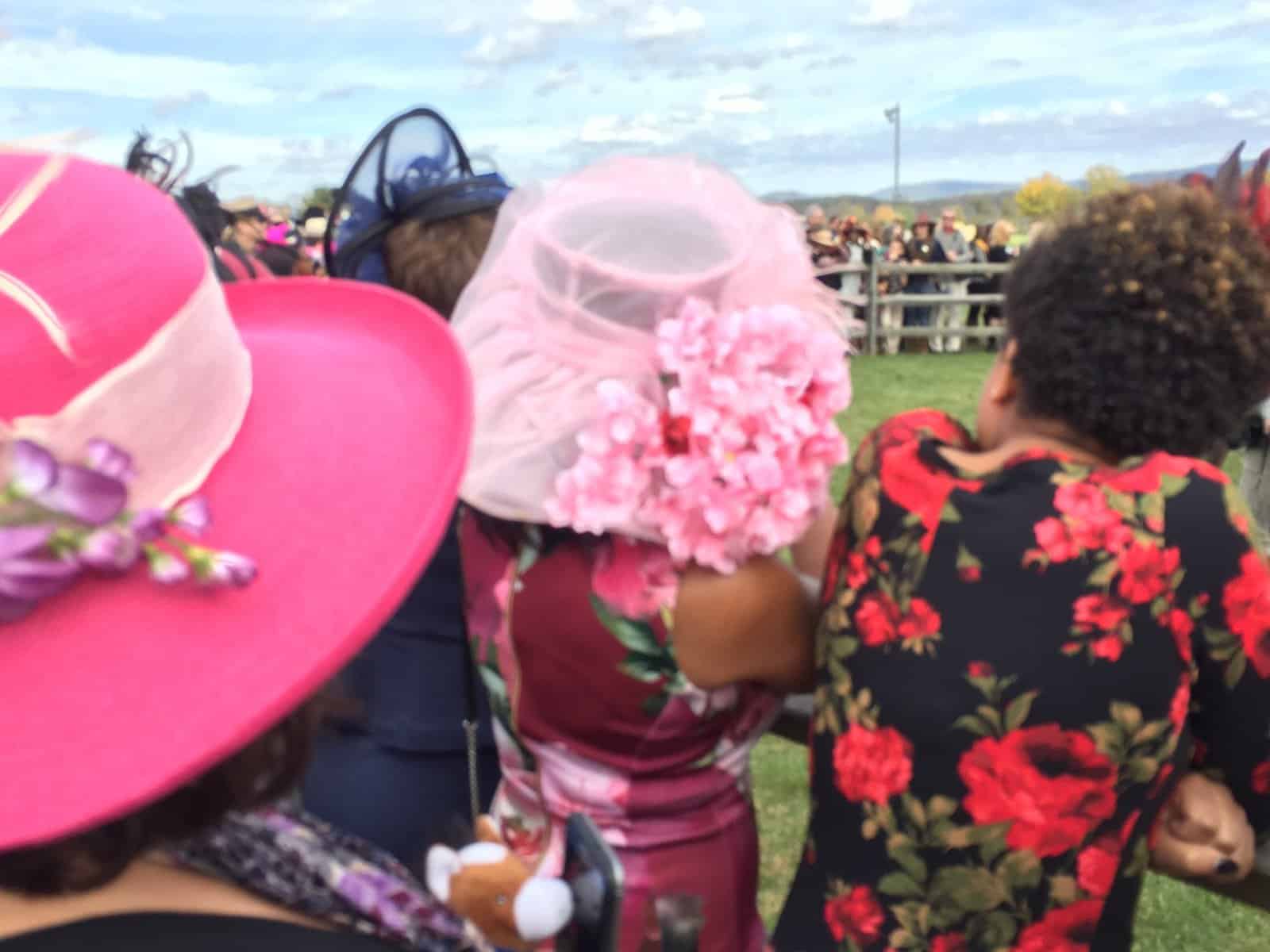 Women wearing hats at horse racing event