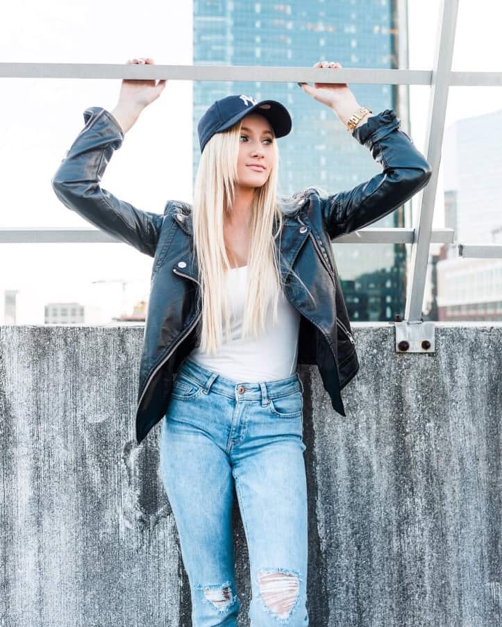 woman wearing a baseball cap with a leather jacket