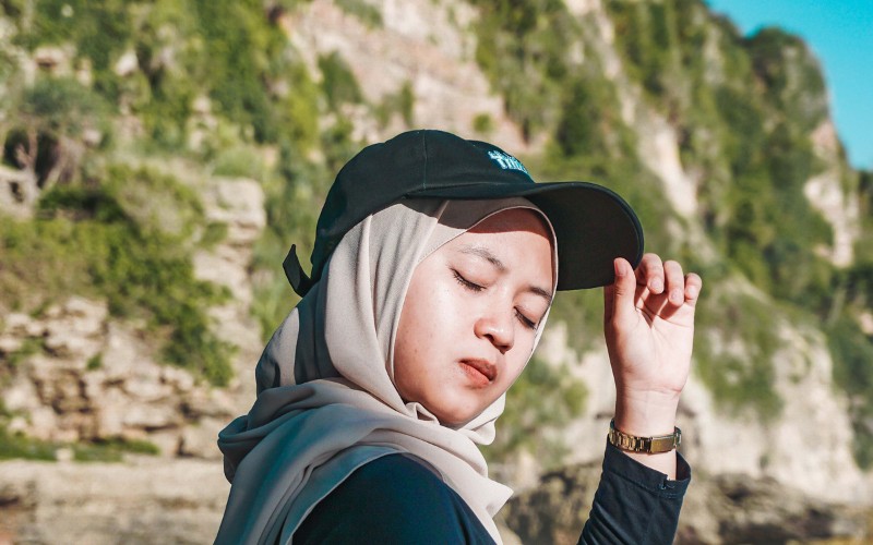 woman casually wearing a baseball cap with a hijab