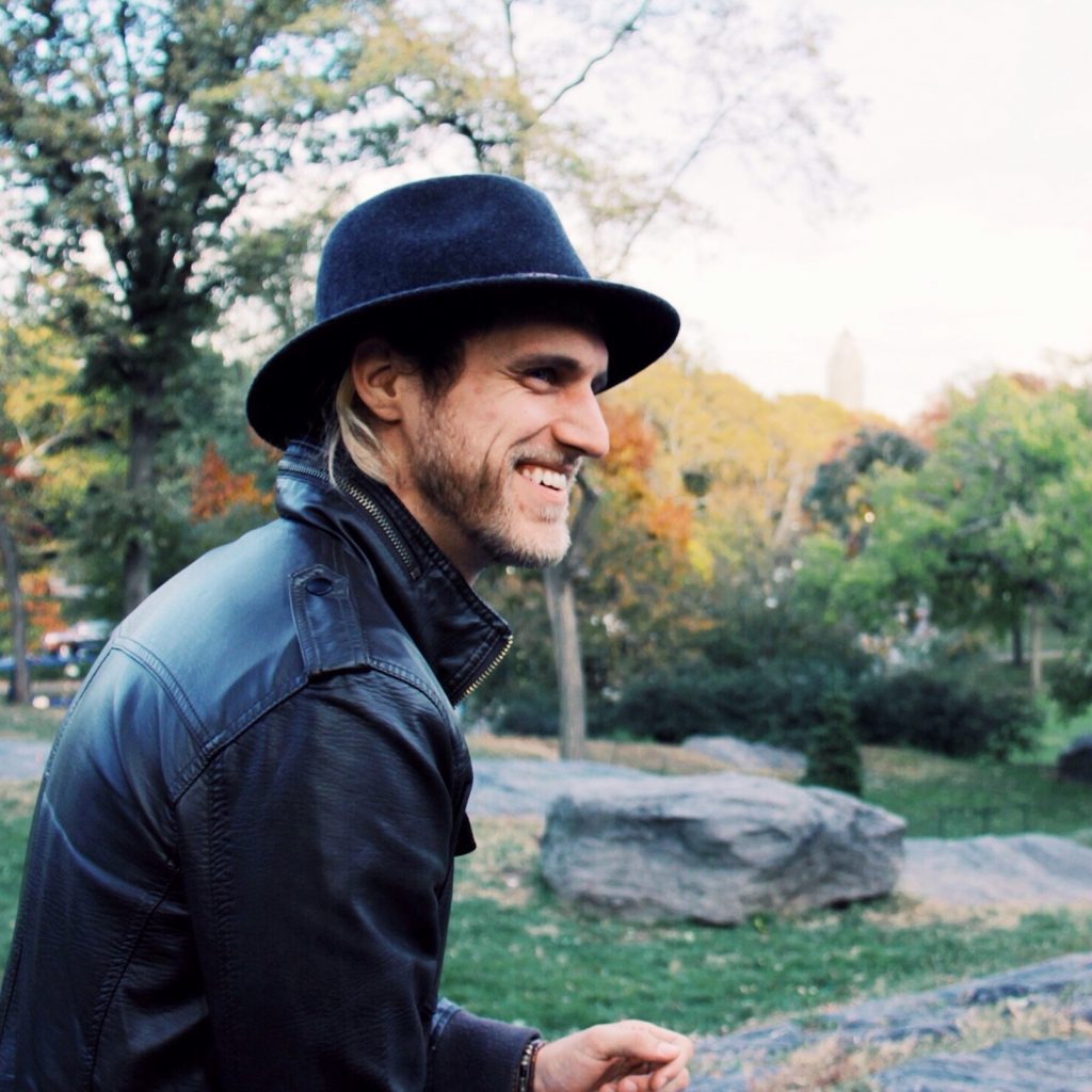 Man wearing a fedora and leather jacket