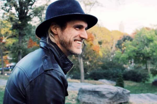 Man wearing a fedora and leather jacket