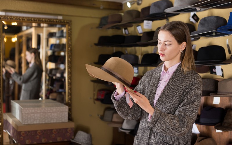 woman examining a hat