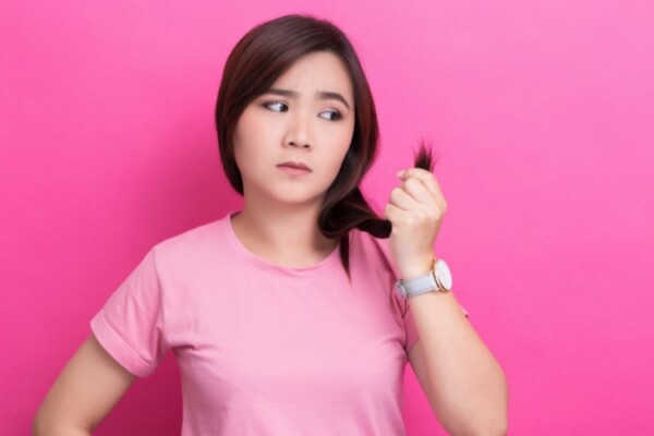 woman holding her hair looking at split ends