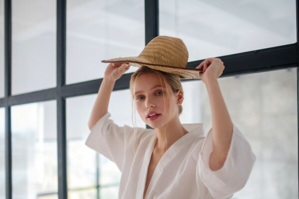 woman adjusting a straw hat