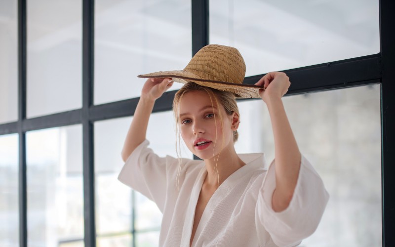 woman adjusting a straw hat