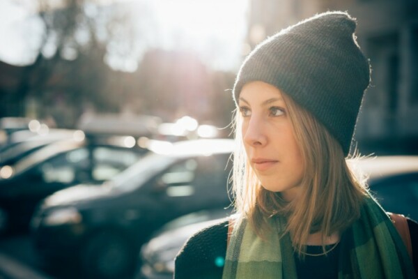 Woman wearing a beanie under the sun in the city