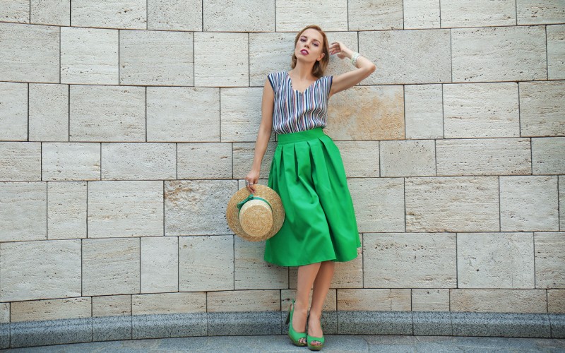 Woman wearing a baoter hat with a green ribbon and green dress