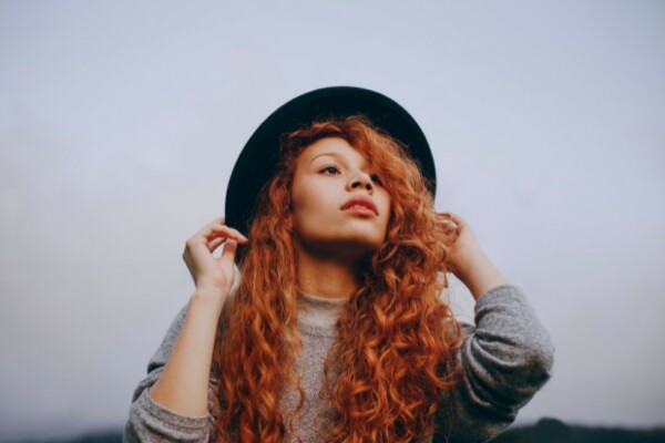 Woman with red hair wearing a black hat