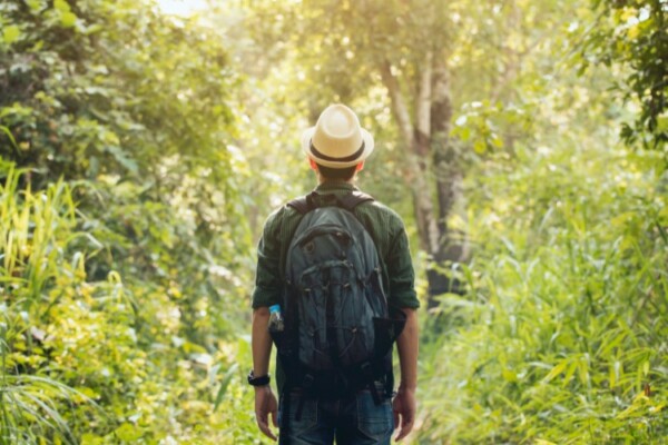 A man hiking wearing a straw hat