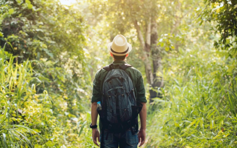 A man hiking wearing a straw hat